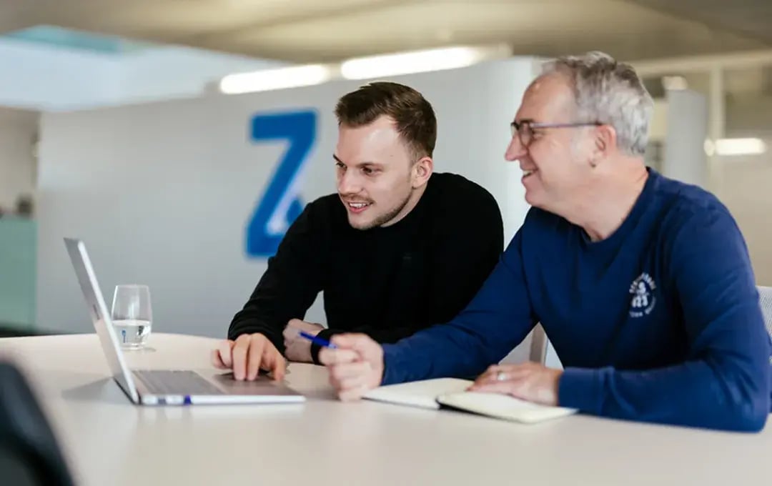 Two men with the Zeit AG logo in the background